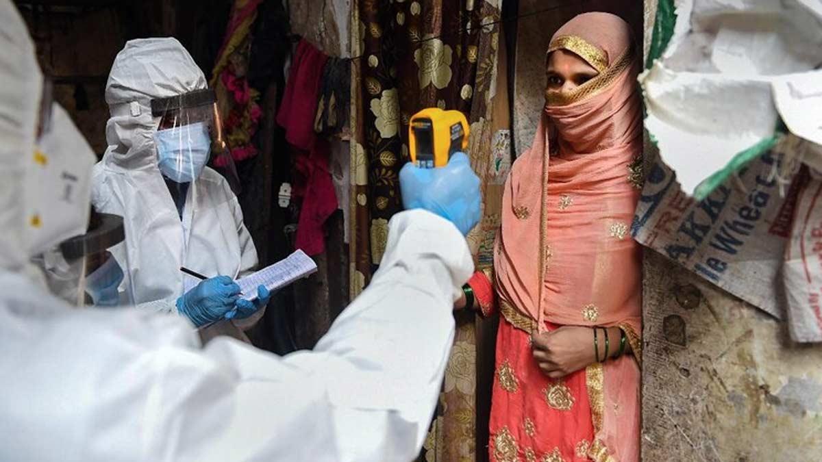 धारावी में एक महिला का स्कैनिंग करता स्वास्थ्यकर्मी (पीटीआई)
