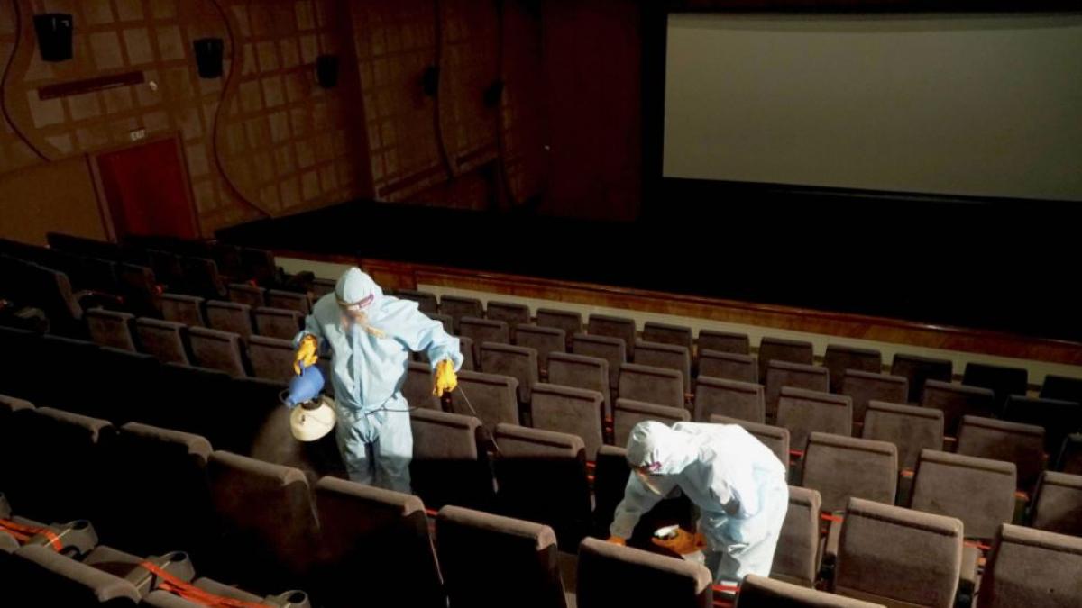 केरल के एक सिनेमा हॉल को सैनिटाइज करते लोग (फोटो-पीटीआई)