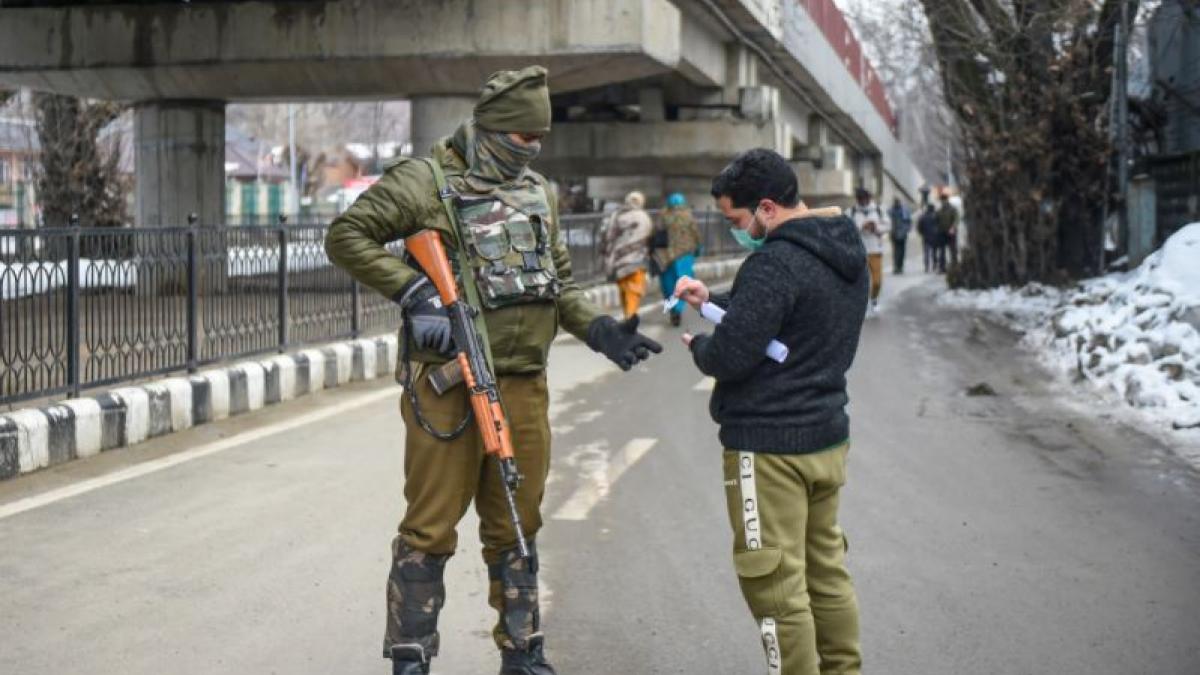 श्रीनगर में तैनात सुरक्षाकर्मी के साथ एक स्थानीय नागरिक (फोटो- पीटीआई)