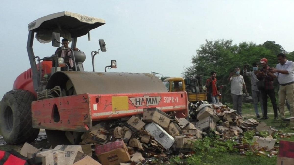 जेसीबी-बुलडोजर के जरिए पुलिस ने नष्ट कराईं शराब की बोतलें.