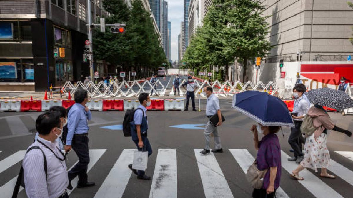  People cross a street next to the Tokyo International Forum. (Getty)