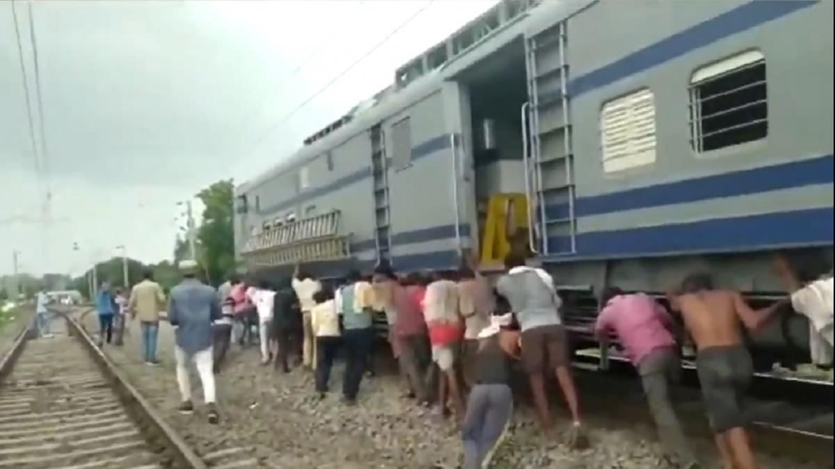 ट्रेन को धक्के लगाते मजदूर