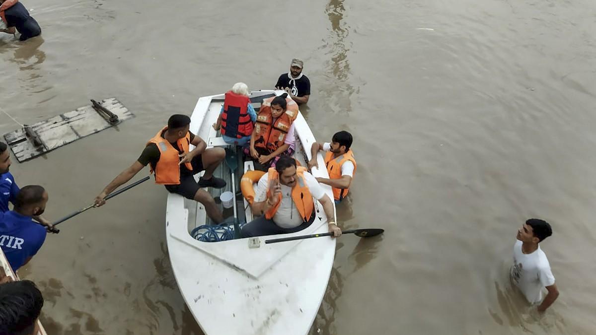 राजकोट में लोगों को सुरक्षित स्थान पर पहुंचाती रेस्क्यू टीम (फोटो- पीटीआई)