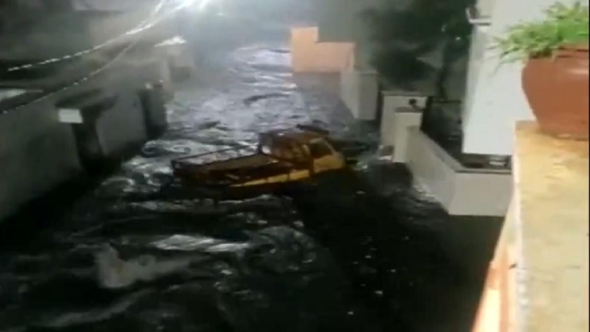 पानी के तेज बहाव में बहता वाहन (फोटोः एएनआई)