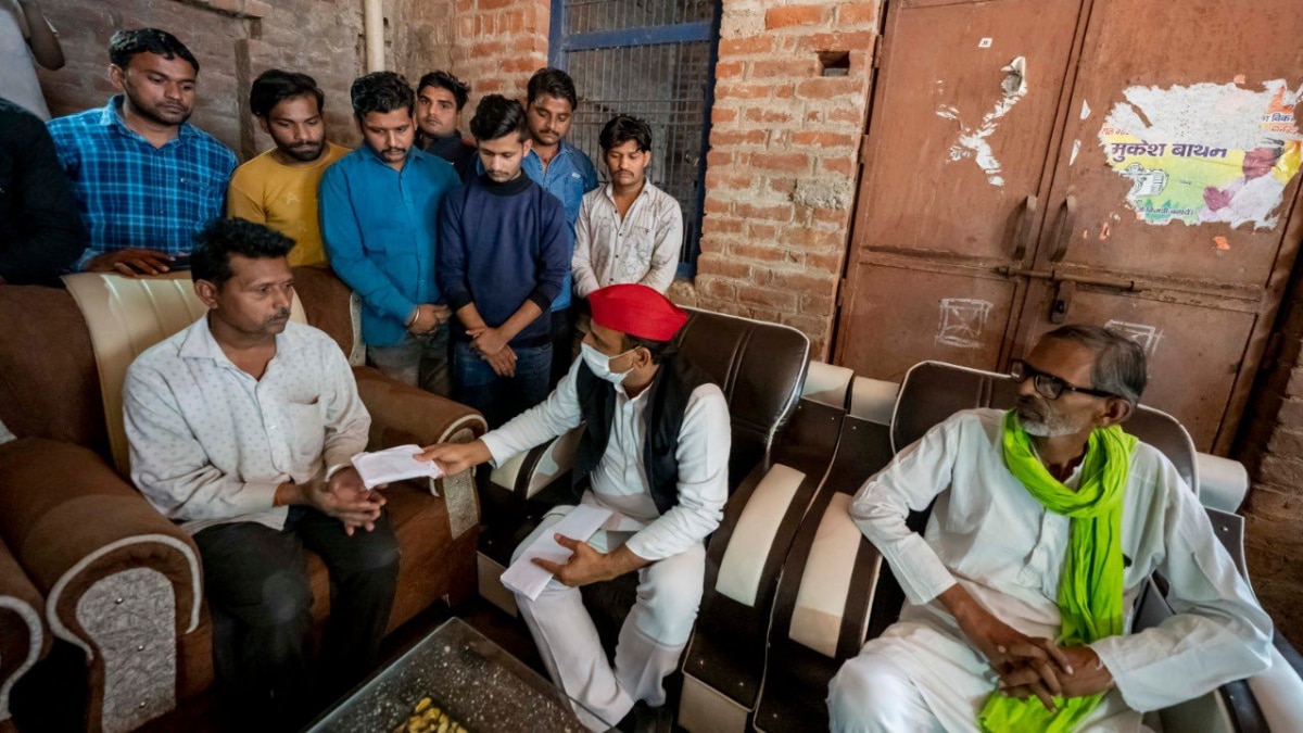 सोफे पर बैठकर पीड़ित परिवार को आर्थिक मदद देते अखिलेश यादव 