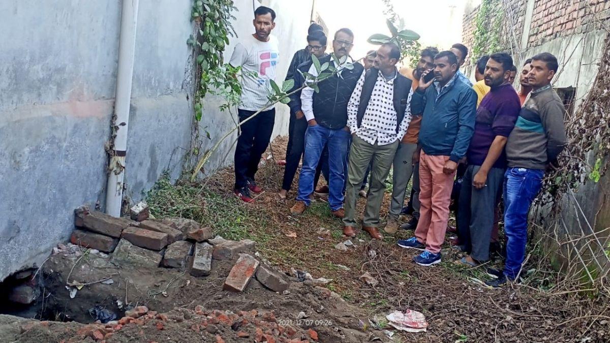 बैंक के पीछे बनी सुरंग देखते लोग