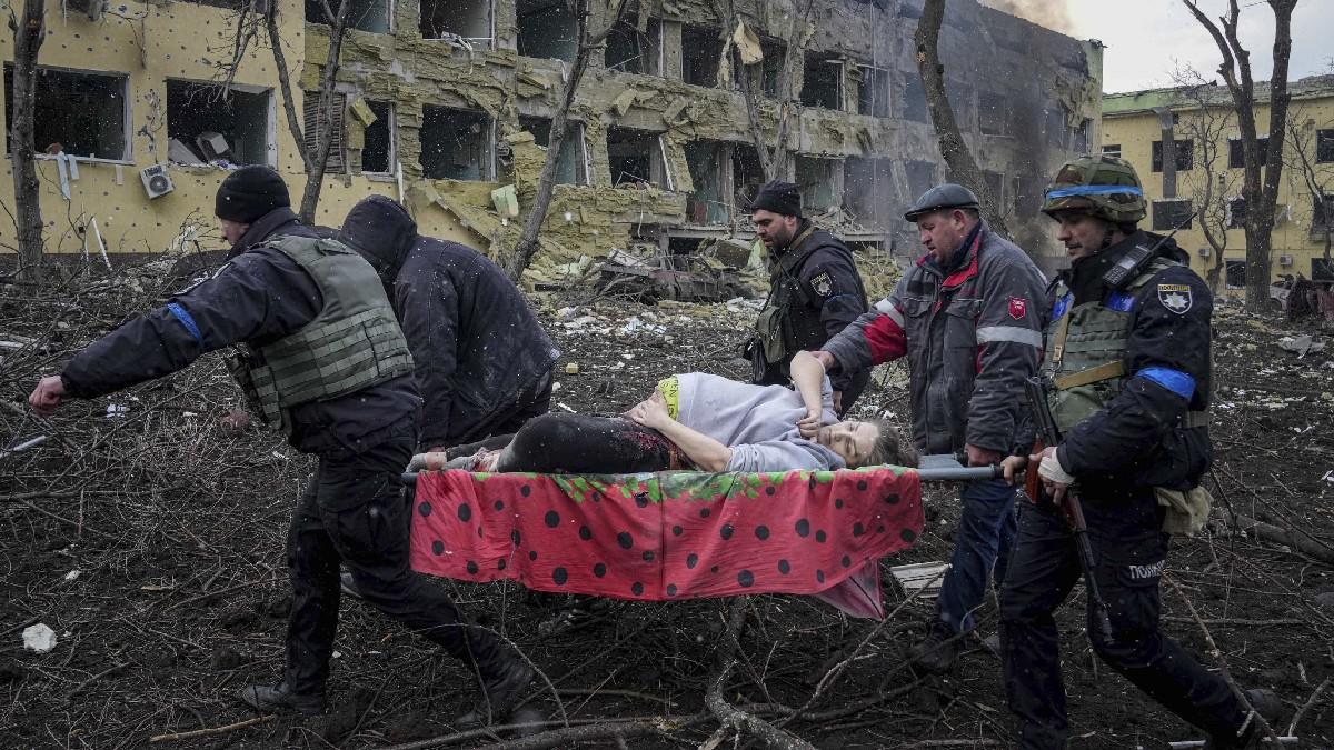 मारियुपोल में बमबारी की चपेट में आई महिला को अस्पताल ले जाते स्वास्थ्य कर्मी (फोटो- पीटीआई)