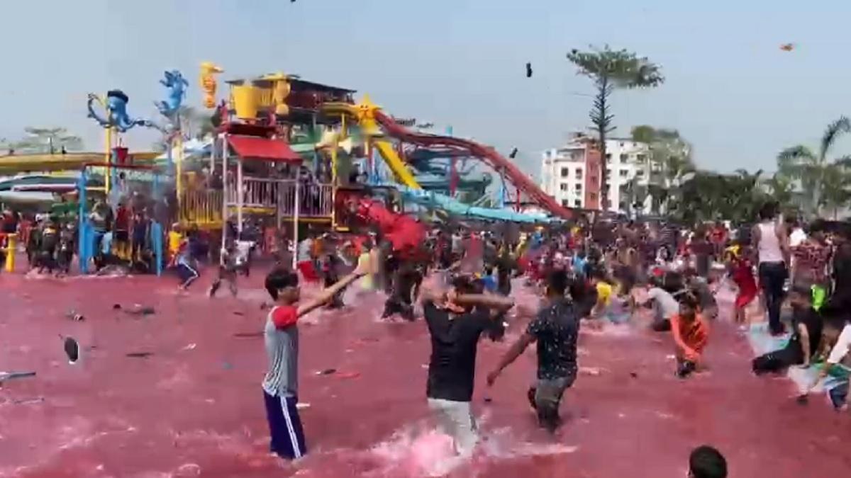 वाटर पार्क में होली के जश्न के दौरान एक-दूसरे पर चप्पल फेंकते लोग