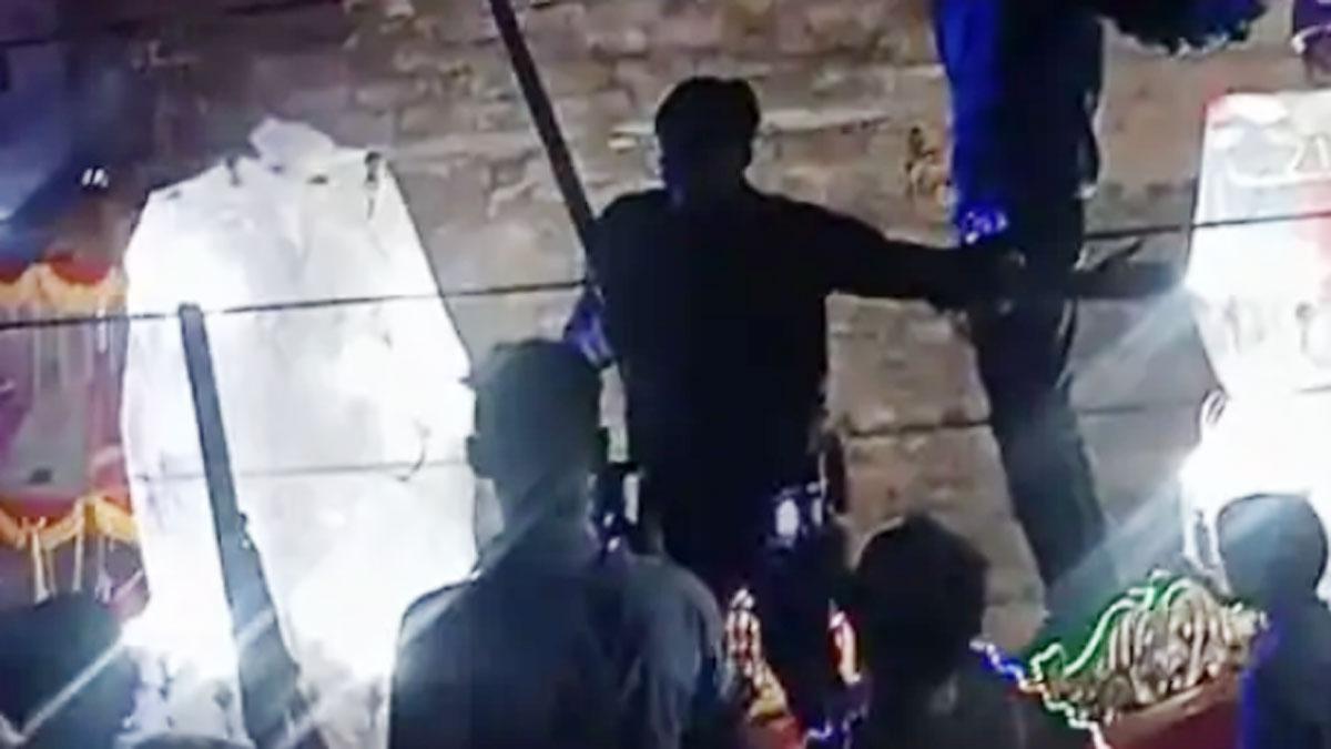 दूल्हे की बग्गी पर चढ़कर राइफल लहराते दो युवक 