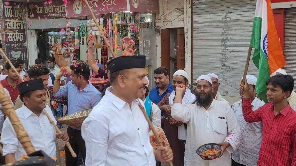 स्वयंसेवकों का फूलों से स्वागत करते मुस्लिम युवा.  (Photo: Aajtak)