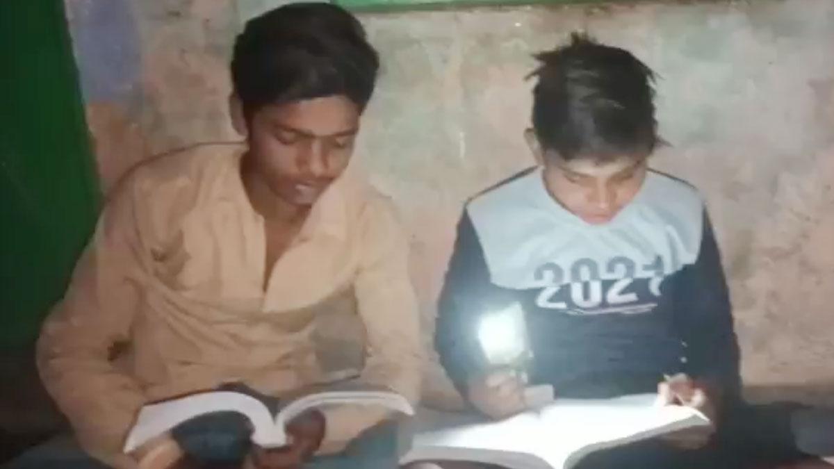 मोबाइल टॉर्च की रोशनी में बोर्ड परीक्षा की तैयारी करते छात्र (फोटो- आजतक) 