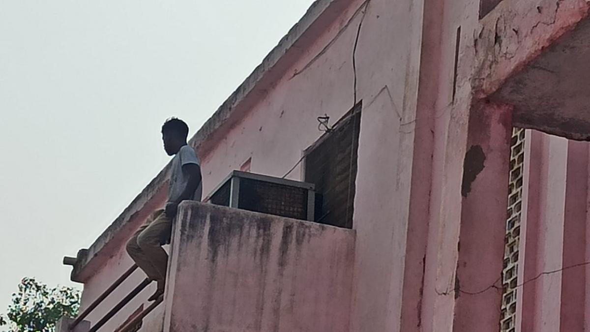 पुलिसकर्मियों पर हमले के बाद छत पर बैठा युवक