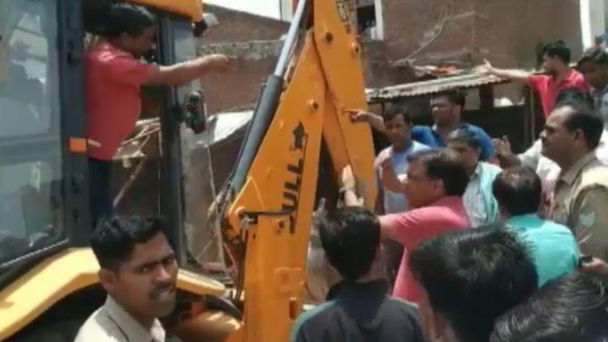 शाहजहांपुर में अतिक्रमण हटाने से नाराज व्यापारी बुलडोजर पर चढ़ गए.