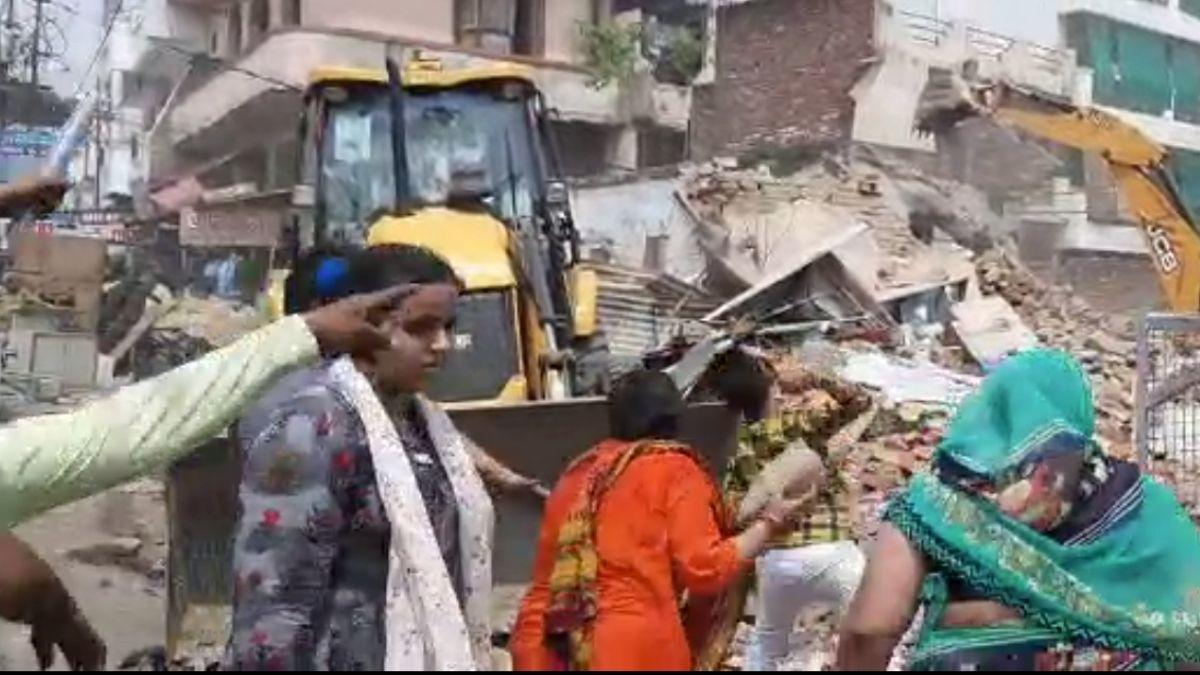 बुलडोजर पर महिलाओं-पुरुषों ने किया पथराव. (Photo: Video Grab)