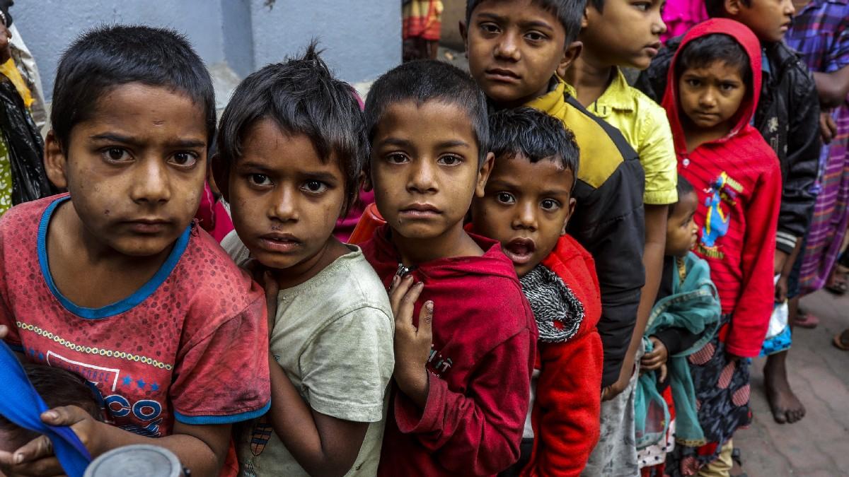 कोलकाता में एनजीओ के सामने खाने के लिए इंतजार करते बच्चे (फोटो- पीटीआई)