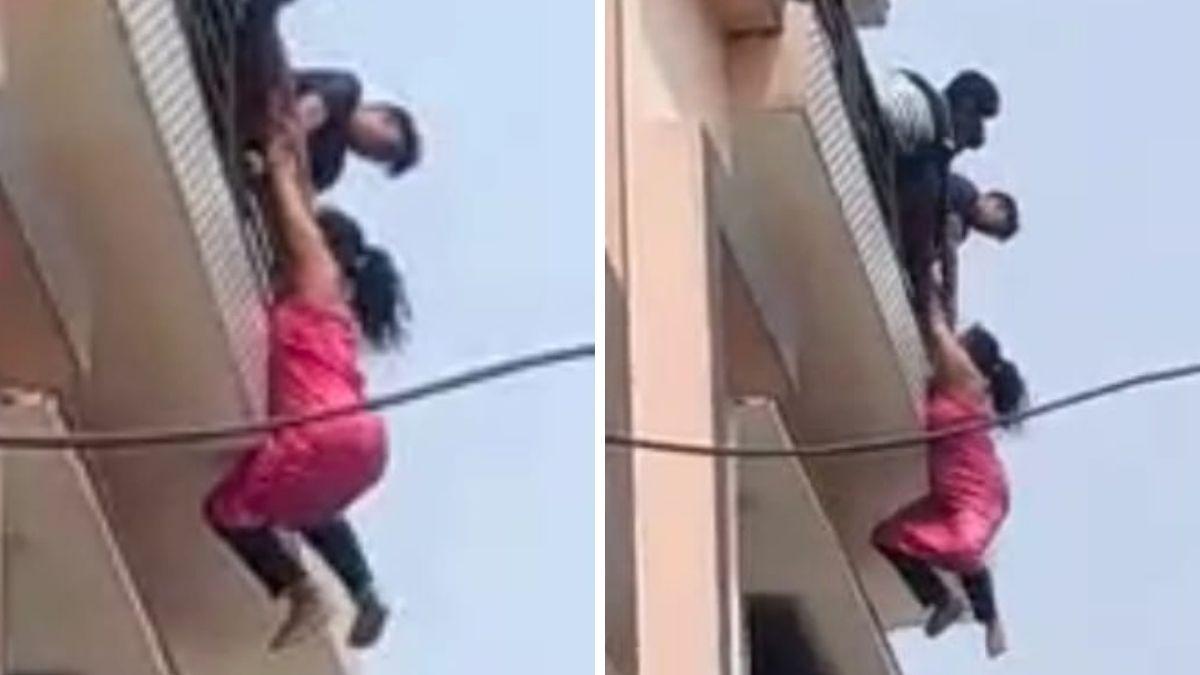 बिल्डिंग की बालकनी से लटकी महिला. (Photo: Video Grab)