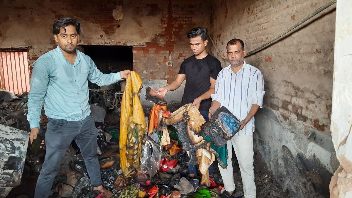 जली साड़ियां दिखाता व्यापारी