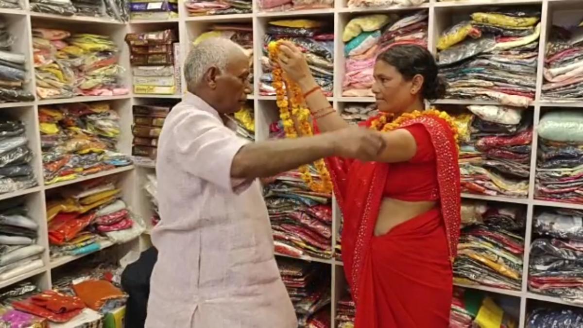 एक दूसरे को माला पहनाते पति और पत्नी