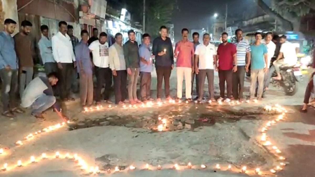 Karnataka: गड्ढों से परेशान लोगों ने अनोखे तरीके से किया विरोध, बीच सड़क दिए जलाकर हुए खड़े