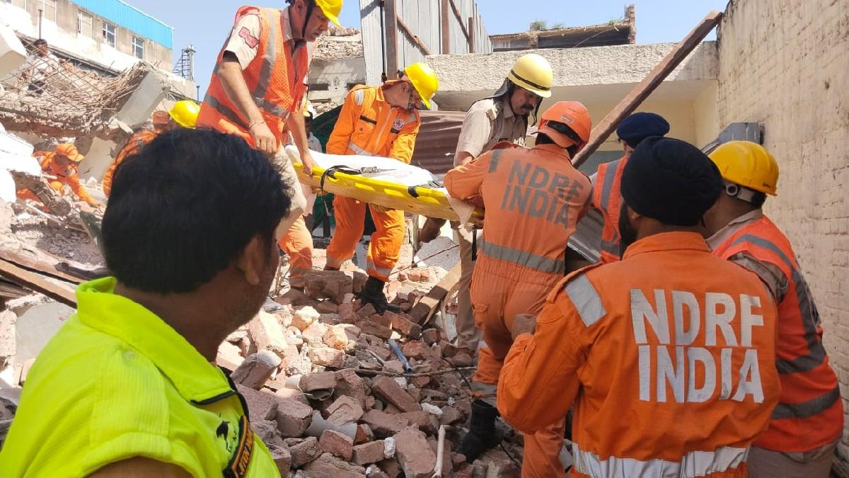 गुरुग्राम में बिल्डिंग ढहने के बाद मलबे से मजदूरों के शव निकालती एनडीआरएफ की टीम.