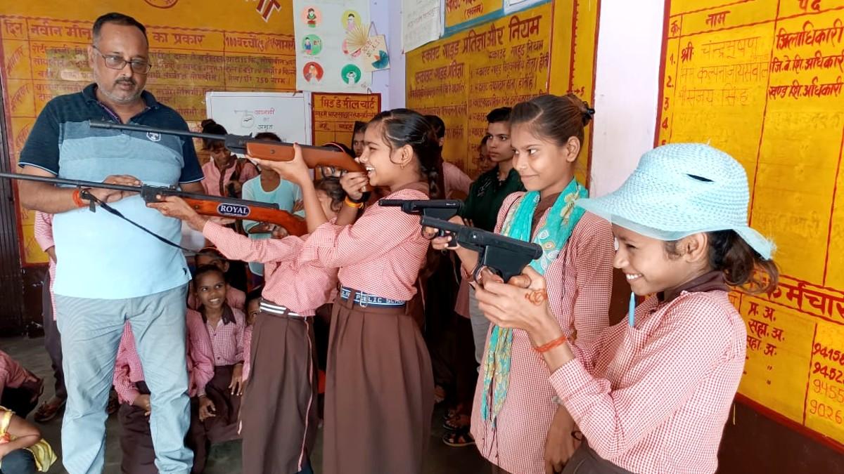 छात्राओं को बंदूक चलाना सिखाता ट्रेनर. 