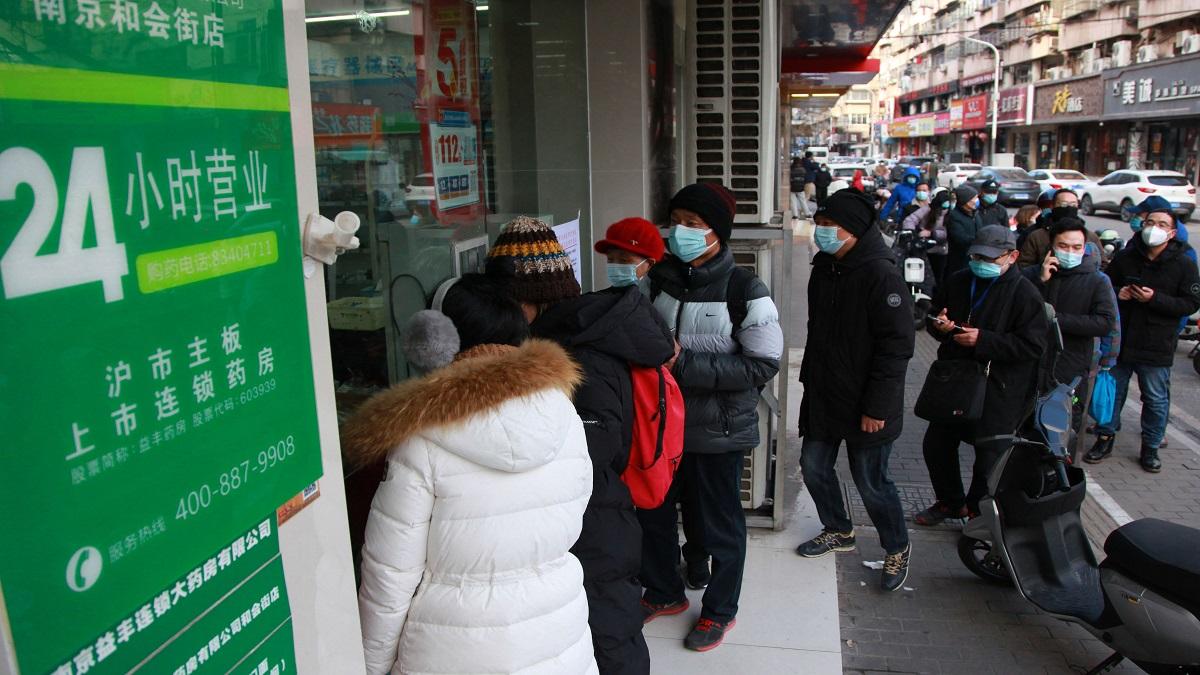 चीन के जियांग्सू में दवा खरीदने के लिए कतार में लगे लोग (फोटो-AFP)