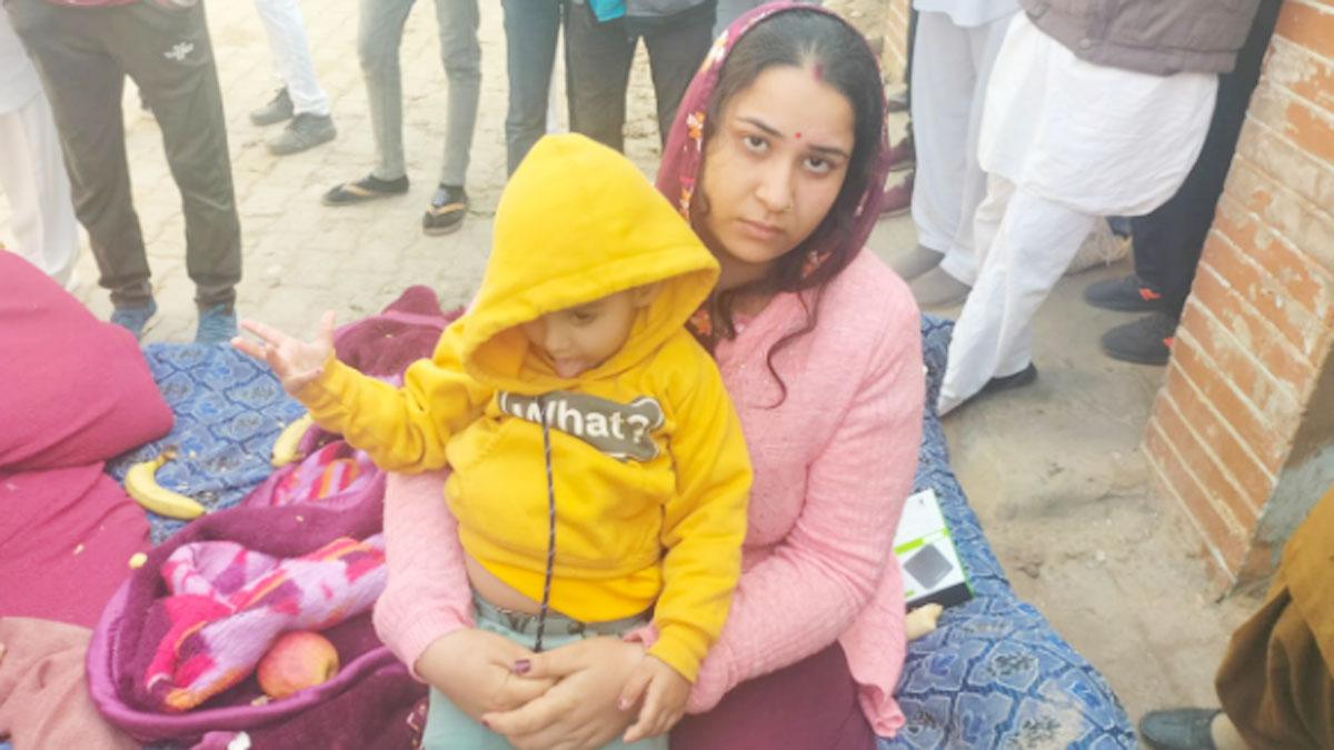 ढाई साल की मासूम बेटी के साथ धरने पर बैठी महिला 