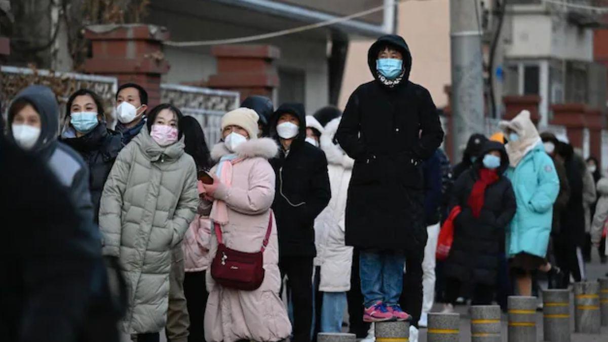 बीजिंग में कोरोना की जांच के लिए लाइन में लगे लोग (फोटो- AFP)