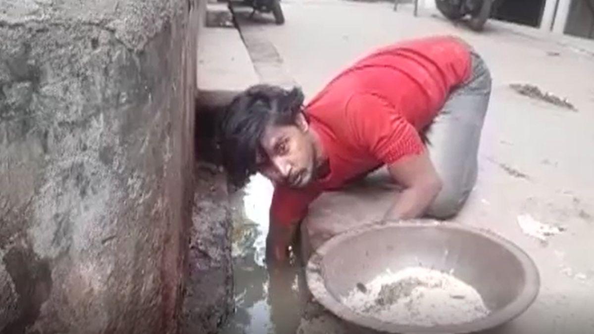 नाली में सोने की तलाश कर रहा युवक.