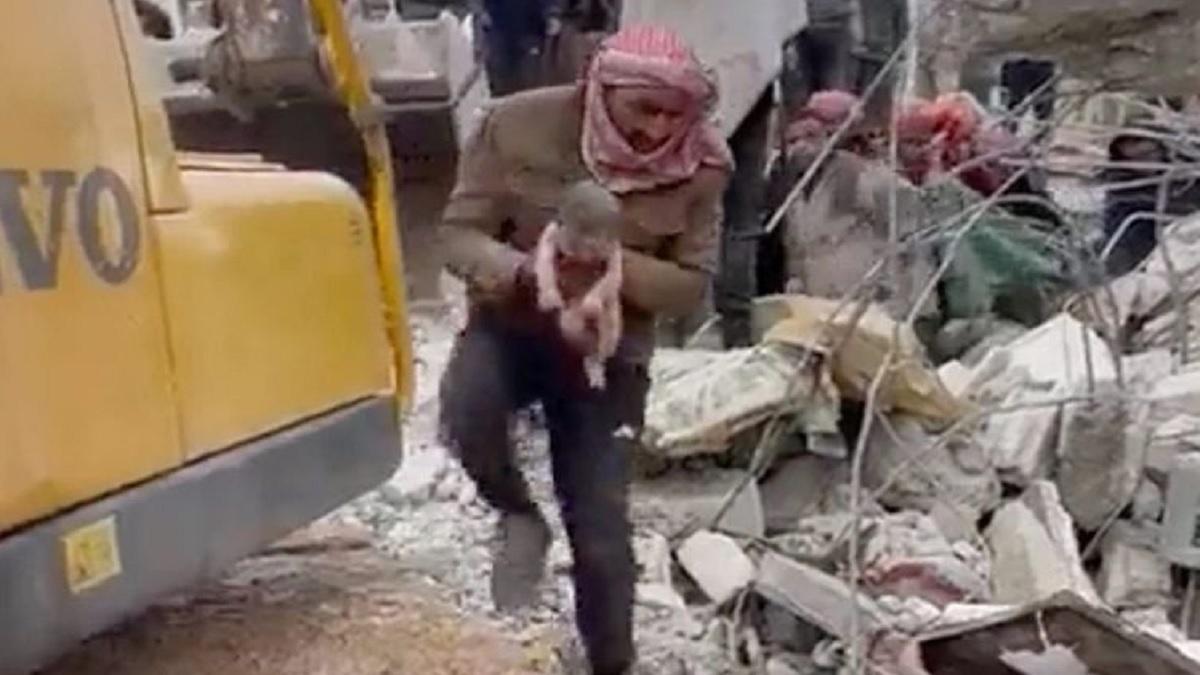 मलबे से निकले नवजात को ले जाता शख्स (Photo-Twitter grab)
