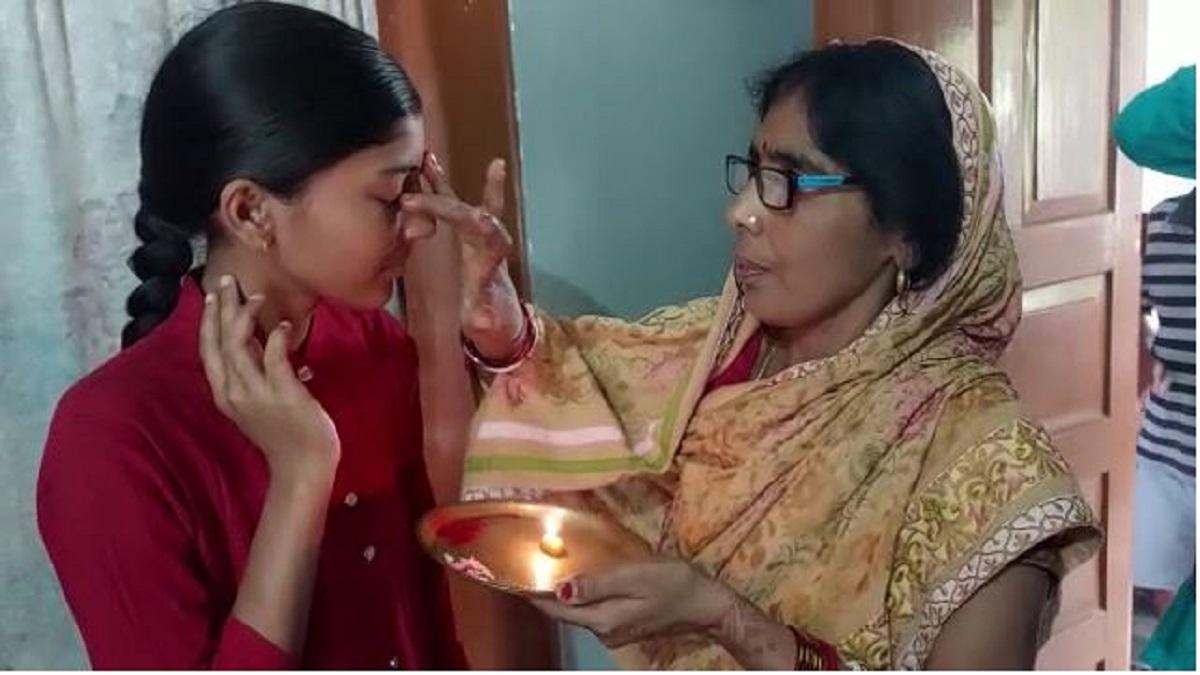 बेटी रक्षा की आरती उतारतीं उसकी मां 