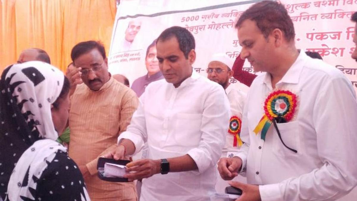 जरूरतमंदों में चश्मा बांटते बीजेपी विधायक पंकज सिंह और वफ़ा अब्बास