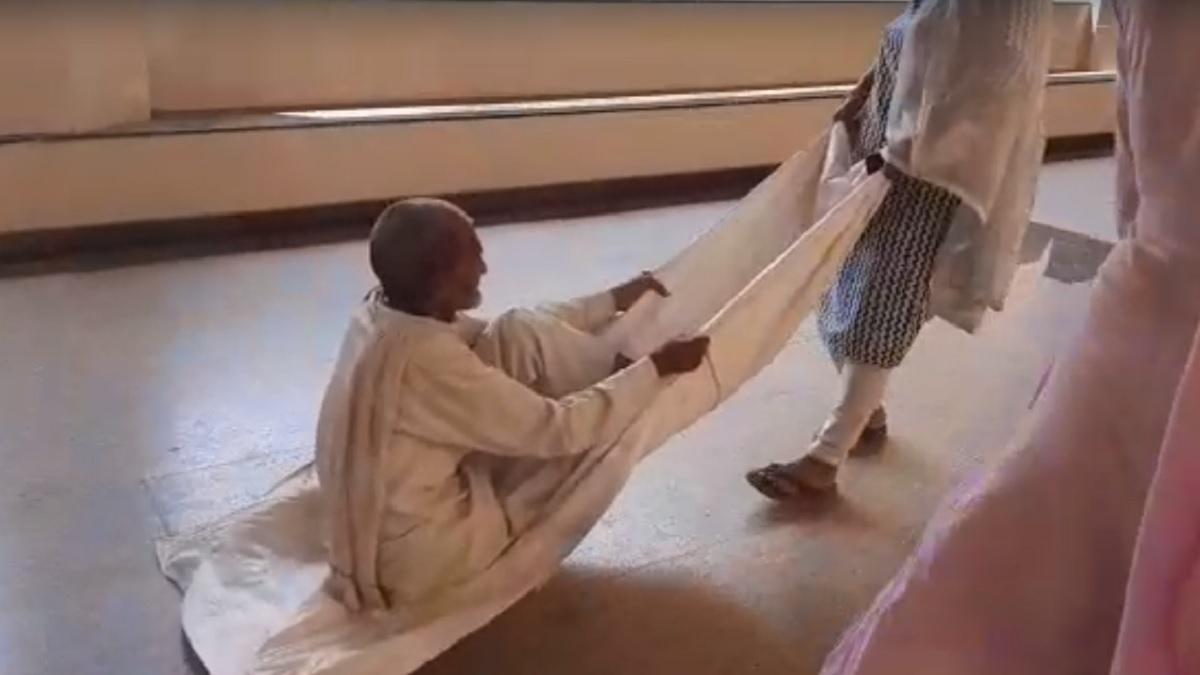 चादर में ससुर को बिठाकर कर खींचती हुए महिला (Video Grab).