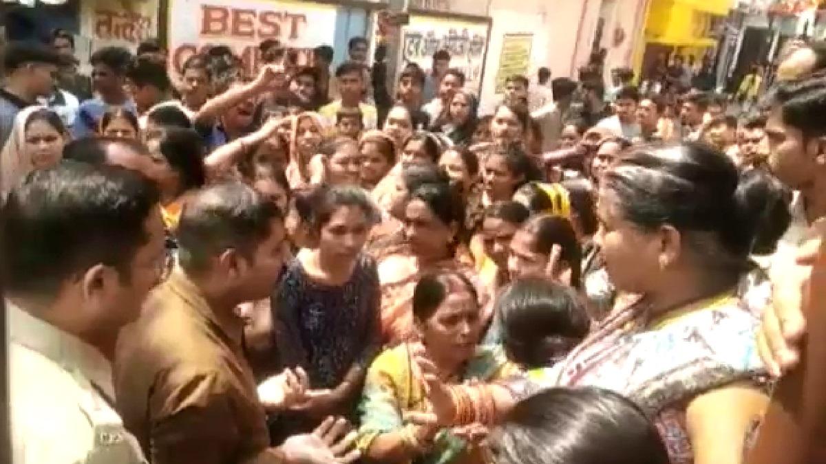 आक्रोशित लोगों को समझाती पुलिस