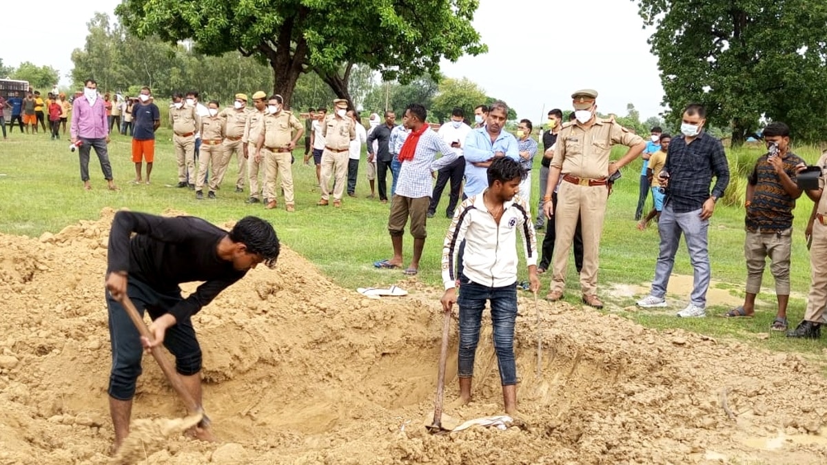 कब्र से नाबालिग का शव निकलवाते पुलिसकर्मी.