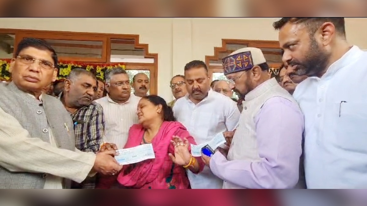 शहीद कैप्टन शुभम की मां को चेक सौंपने की कोशिश करते मंत्री योगेश उपाध्याय.