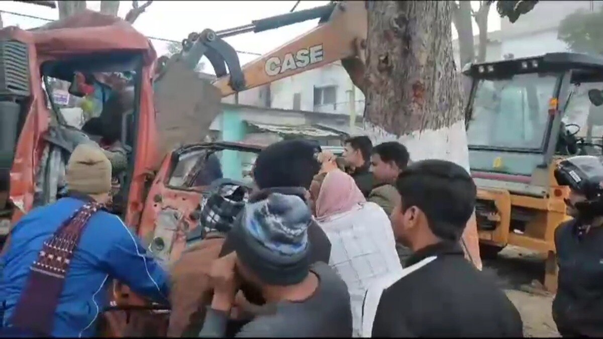 पेड़ से टकराने के बाद ट्रक में फंसे ड्राइवर को निकालने की कोशिश करती पुलिस.