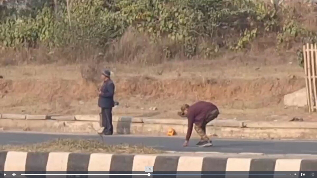 सड़क से नोट उठाता पुलिसकर्मी