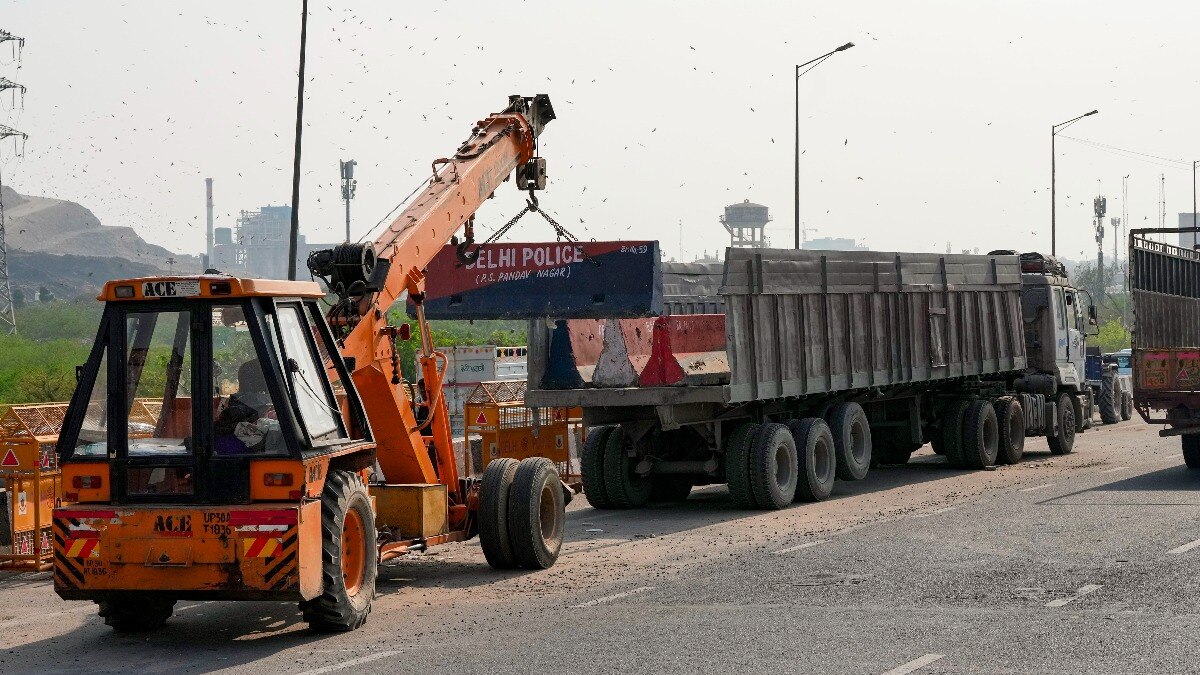 गाजीपुर सीमा से बैरिकेड हटाती हुई दिल्ली पुलिस 