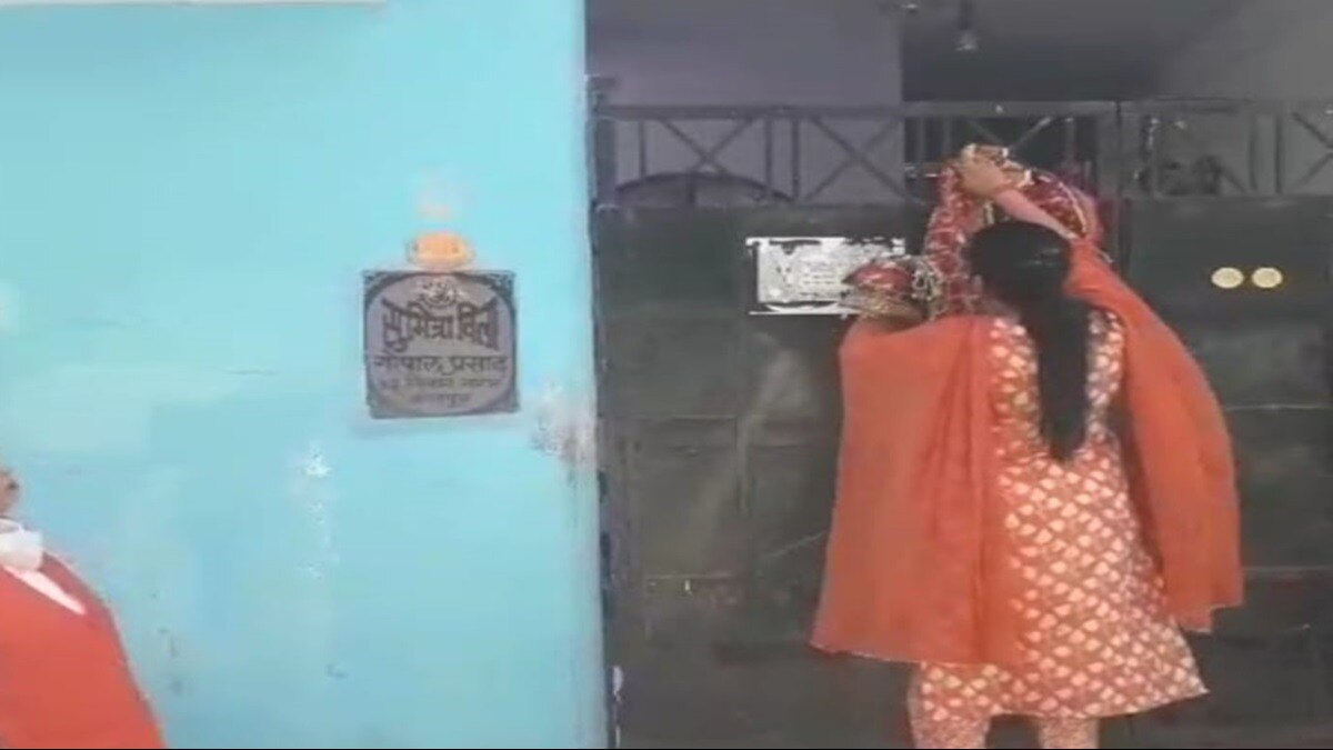 दरवाजे पर चुनरी बांधती महिला