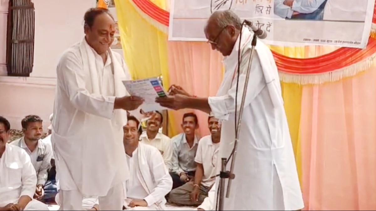 छोटे भाई लक्ष्मण सिंह के हाथों में गारंटी कार्ड सौंपते हुए दिग्विजय.