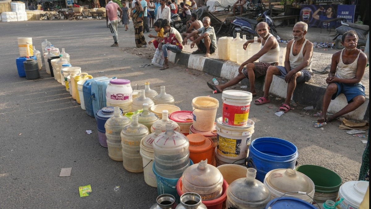 पूर्वी दिल्ली के गीता कॉलोनी इलाके में दिल्ली जल बोर्ड के टैंकर से पीने का पानी लेने का इंतजार करते हुए लोग (फोटो- पीटीआई)