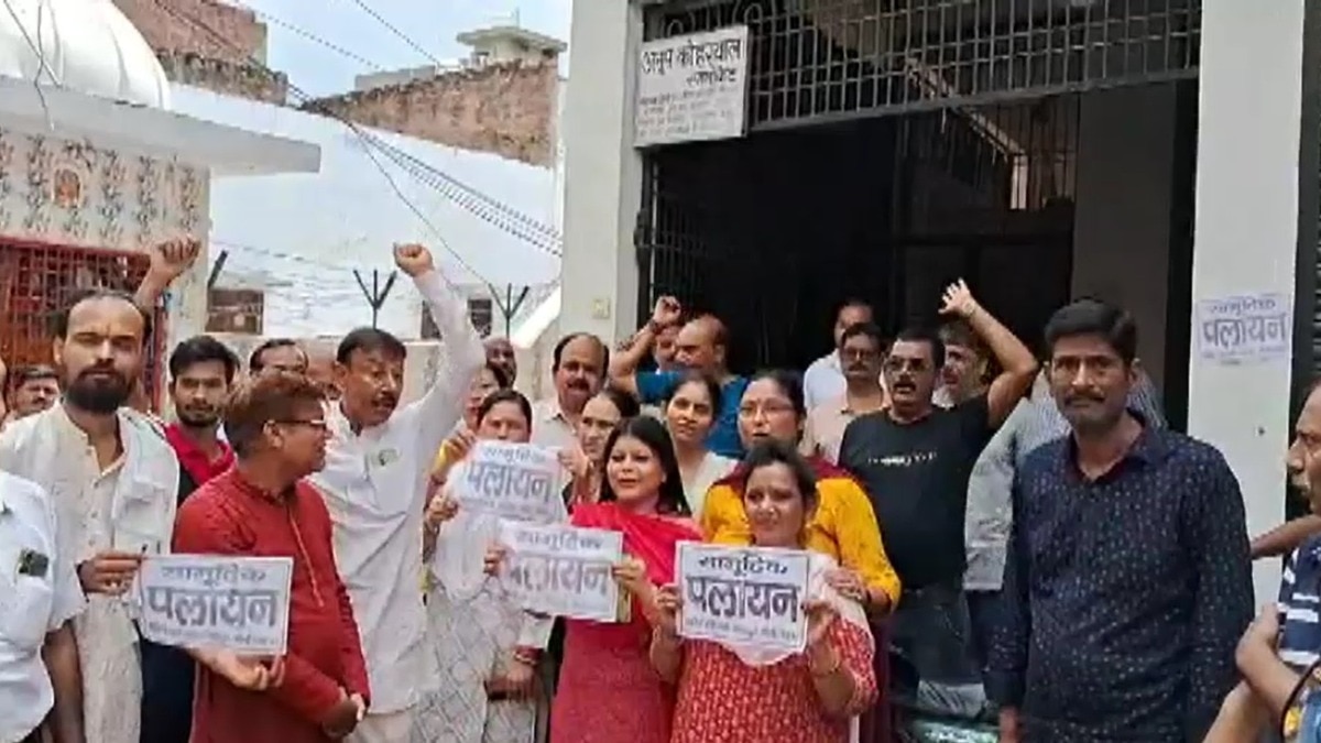 बरेली के एक मोहल्ले में पलायन का पोस्टर लेकर खड़े लोग