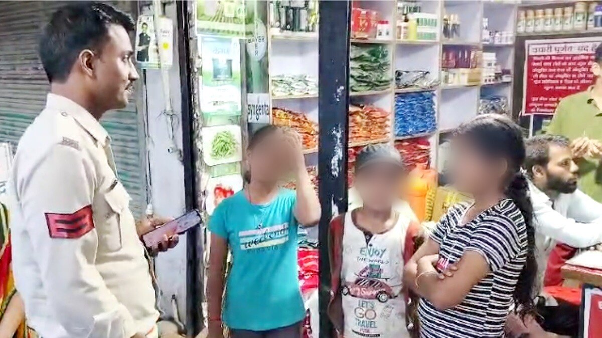 बच्चों से बातचीत करता पुलिसकर्मी.