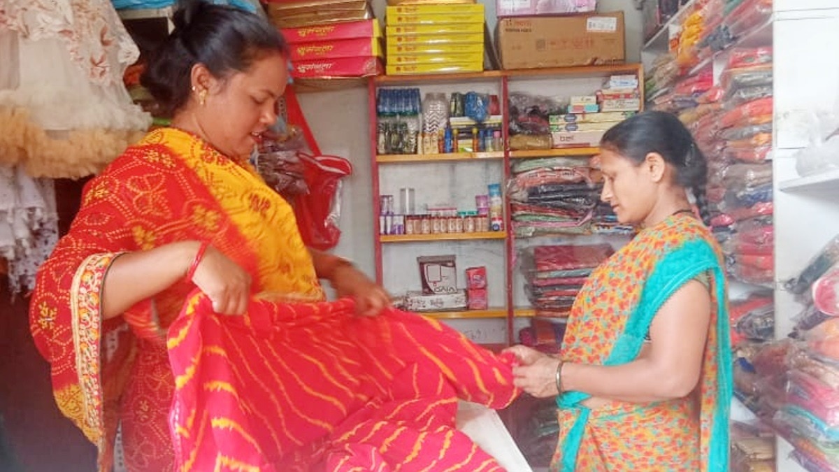 अपनी दुकान पर महिला ग्राहक को साड़ी दिखाती जयपाली.