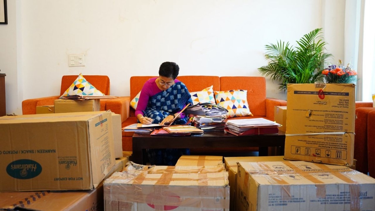 अपने घर पर फाइल पर हस्ताक्षर करती हुईं सीएम आतिशी