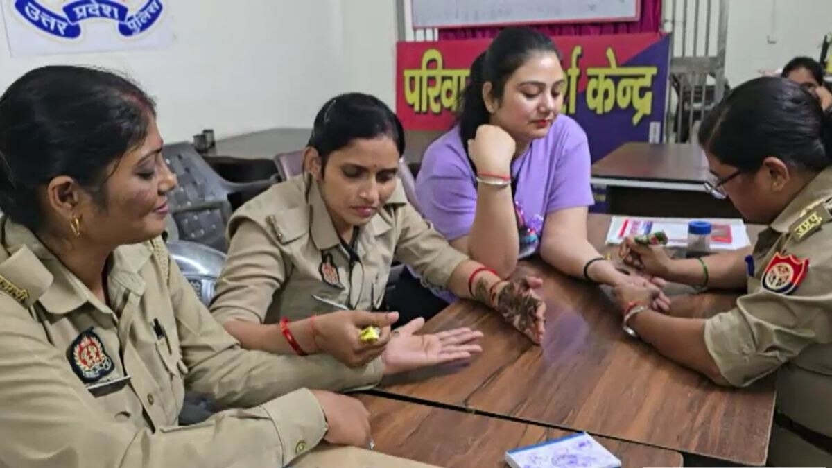 थाने में मेहंदी लगवातीं महिला पुलिसकर्मी.
