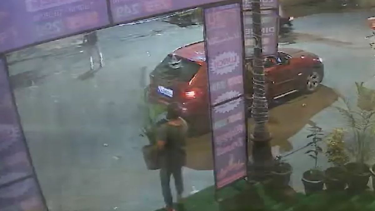 दुकान के सामने से गमला उठाती महिला. (Video Grab)