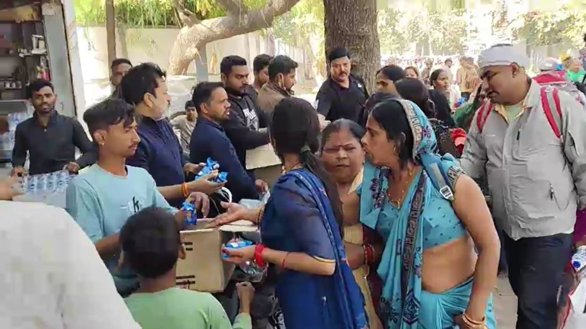 श्रद्धालुओं को बिस्किट और पानी बांट रहे लोग. (Screengrab)