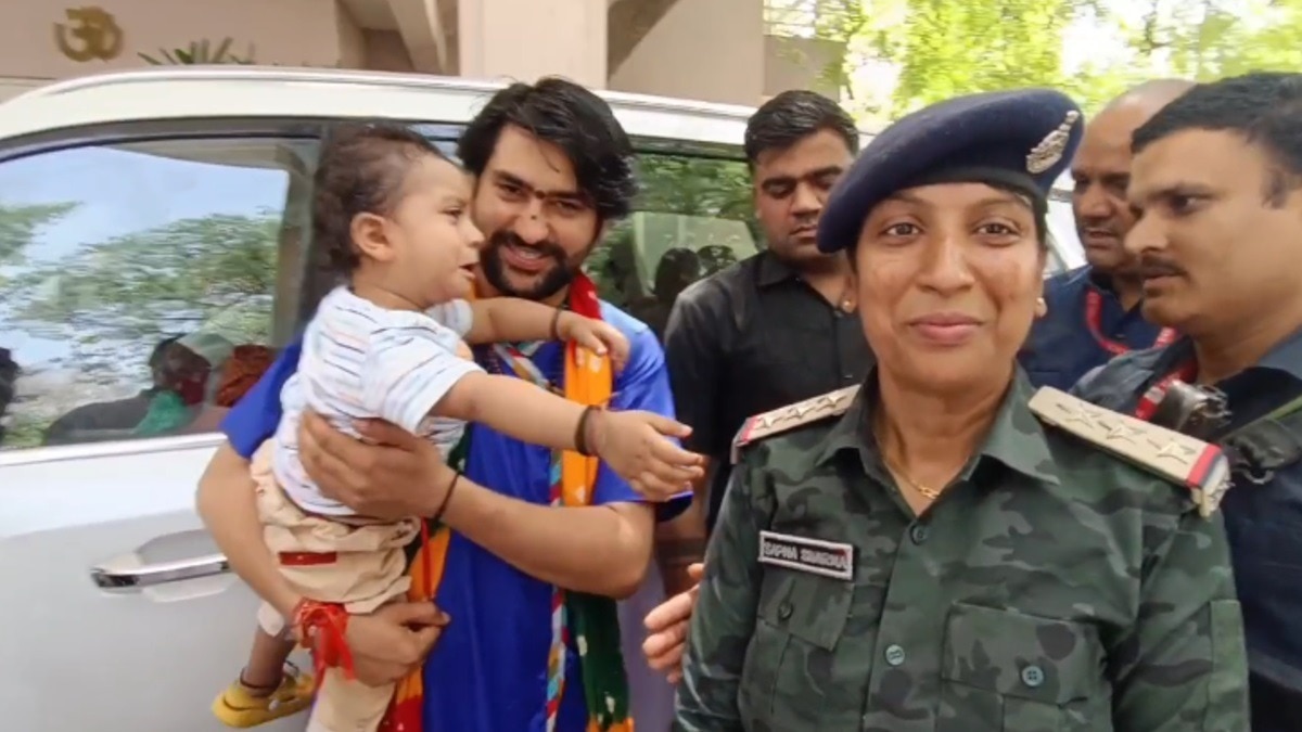 महिला इंस्पेक्टर के बच्चे को दुलारते हुए धीरेंद्र शास्त्री.